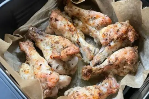 Chrupiące skrzydełka kurczaka w air fryer, przyprawione ziołami, gotowe do podania.