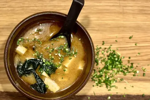 A miseczka zupy miso z tofu i wodorostami, posypana szczypiorkiem. Idealny przepis na rozgrzewającą zupę miso.