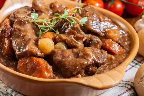 Aksamitna wołowina w sosie z pieczarkami i cebulką, udekorowana gałązką tymianku. Idealna na chłodne dni.