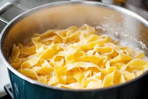 Szeroki makaron tagliatelle gotuje się w garnku. Idealny do prostych, pysznych przepisów.