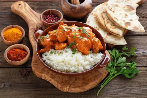 Pyszny kurczak tikka masala przepis: kremowy sos, ryż i chlebki naan.