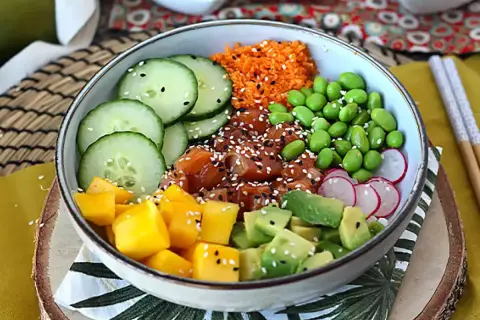 Kolorowy poke bowl z łososiem, mango, awokado, ogórkiem, edamame i rzodkiewką. Idealny przepis na zdrowy posiłek.