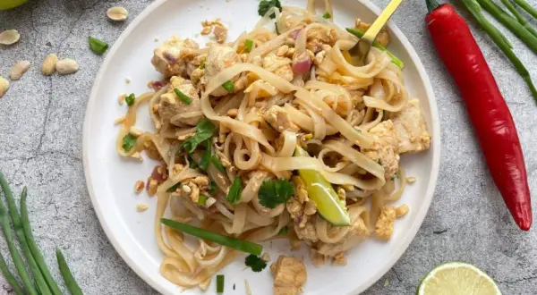 Pyszny makaron do pad thai z kurczakiem, orzeszkami ziemnymi i limonką. Idealny na szybki obiad.