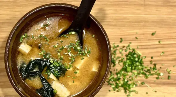 A miseczka zupy miso z tofu i wodorostami, posypana szczypiorkiem. Idealny przepis na rozgrzewającą zupę miso.