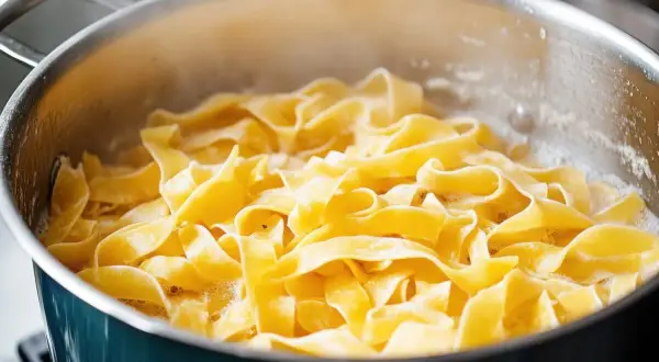 Szeroki makaron tagliatelle gotuje się w garnku. Idealny do prostych, pysznych przepisów.