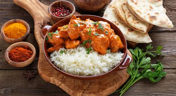 Pyszny kurczak tikka masala przepis: kremowy sos, ryż i chlebki naan.