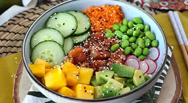 Kolorowy poke bowl z łososiem, mango, awokado, ogórkiem, edamame i rzodkiewką. Idealny przepis na zdrowy posiłek.
