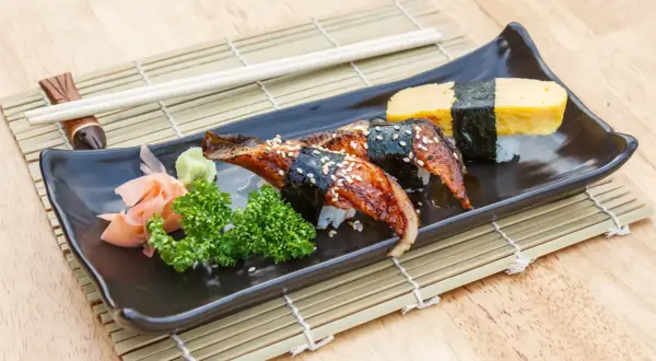 Sushi z węgorzem w sosie unagi. Co to za pyszny sos? Na talerzu też tamago, wasabi i marynowany imbir.