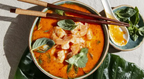Aksamitny, pomarańczowy bulion z krewetkami i ziołami, idealny do jedzenia pałeczkami. To pyszne danie to klasyczne **pasta tom yum**.