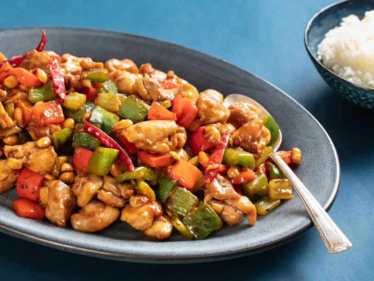 Pyszny kurczak kung pao z orzeszkami ziemnymi, papryką i chili na talerzu.