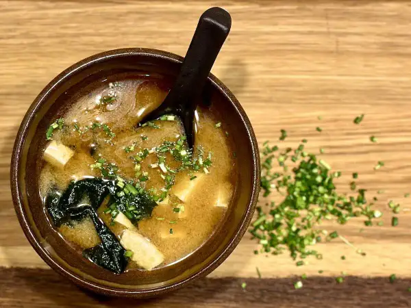 A miseczka zupy miso z tofu i wodorostami, posypana szczypiorkiem. Idealny przepis na rozgrzewającą zupę miso.