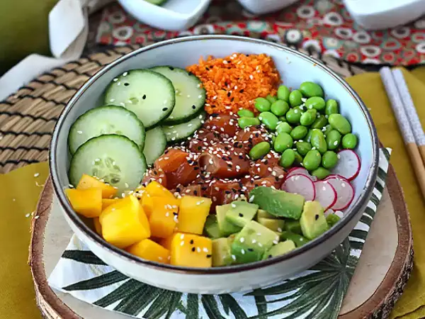 Kolorowy poke bowl z łososiem, mango, awokado, ogórkiem, edamame i rzodkiewką. Idealny przepis na zdrowy posiłek.