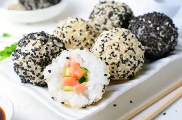 Kuleczki ryżowe z łososiem i ogórkiem, obtoczone w sezamie. Idealne składniki na sushi.